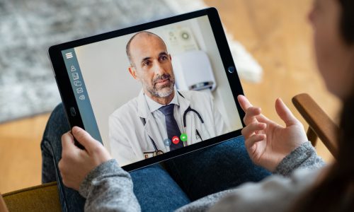 Een persoon videobelt met een tablet met een arts. Een vorm van eHealth