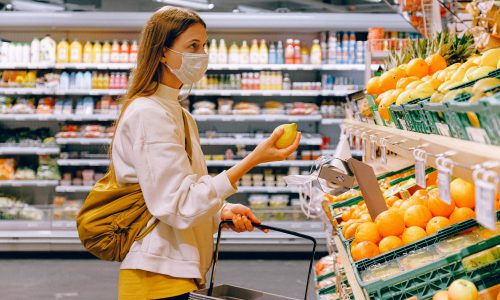 Een vrouw met een citroen in haar hand voor een groente-/fruitschap in een supermarkt, illustratiEen vrouw met een citroen in haar hand voor een groente-/fruitschap in een supermarkt, illustratief voor het artikel over supermarktenef