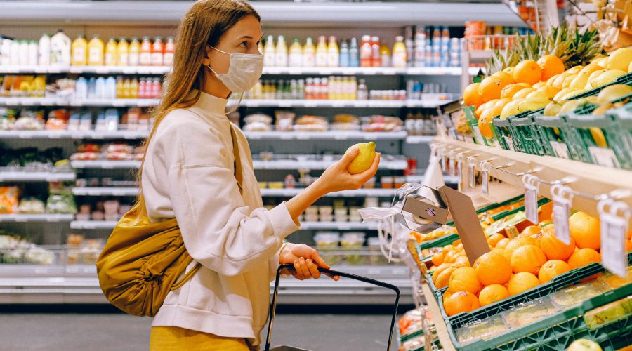 Een vrouw met een citroen in haar hand voor een groente-/fruitschap in een supermarkt, illustratiEen vrouw met een citroen in haar hand voor een groente-/fruitschap in een supermarkt, illustratief voor het artikel over supermarktenef