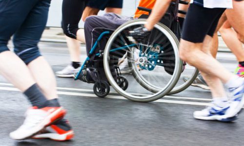 Een man in een rolstoel tijdens een hardloopwedstrijd. Illustratief voor artikel over de Community Challenge van Hieroo.