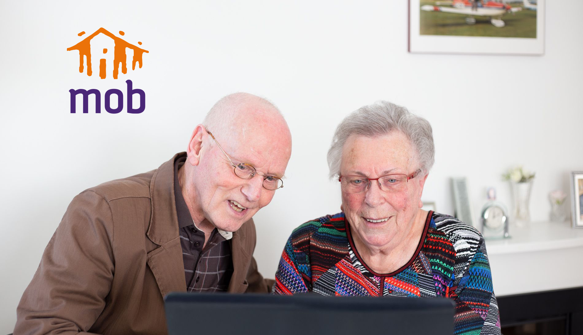Twee ouderen achter een laptop.