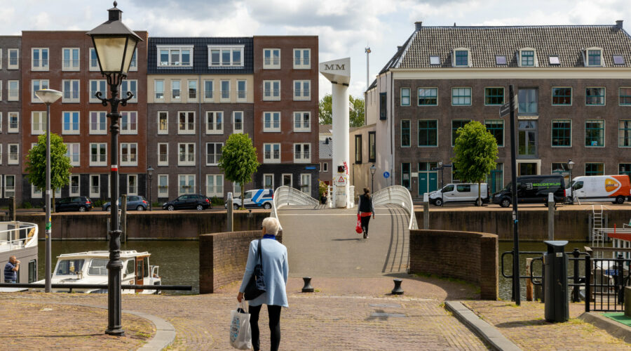 Een oudere loopt met een boodschappentas in Delfshaven. Illustratief voor bij het artikel over de cursus valpreventie. Foto van Irene Hoekstra