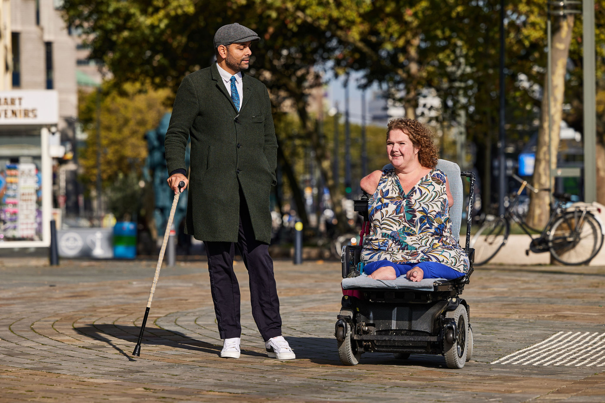 Man met een wandelstok en vrouw in een aangepaste rolstoel