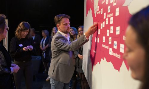 Partners plakken stickers op de kaart van regio Rotterdam-Rijnmond met de naam van hun organisatie