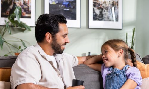 Man en kind zitten op de bank en kijken elkaar aan