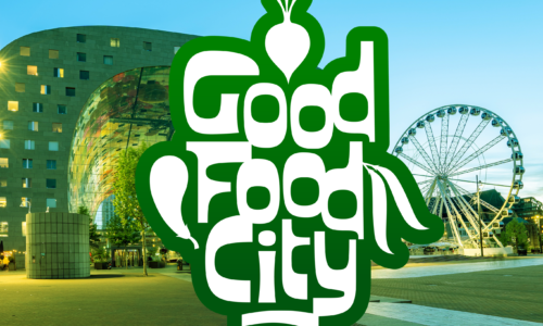 Het logo van Good Food City, met op de achtergrond een foto van de markthal in Rotterdam en een reuzenrad. Het logo zelf bestaat uit de tekst Good Food City in groene speelse letters, met daarin een ui en aubergine verwerkt.