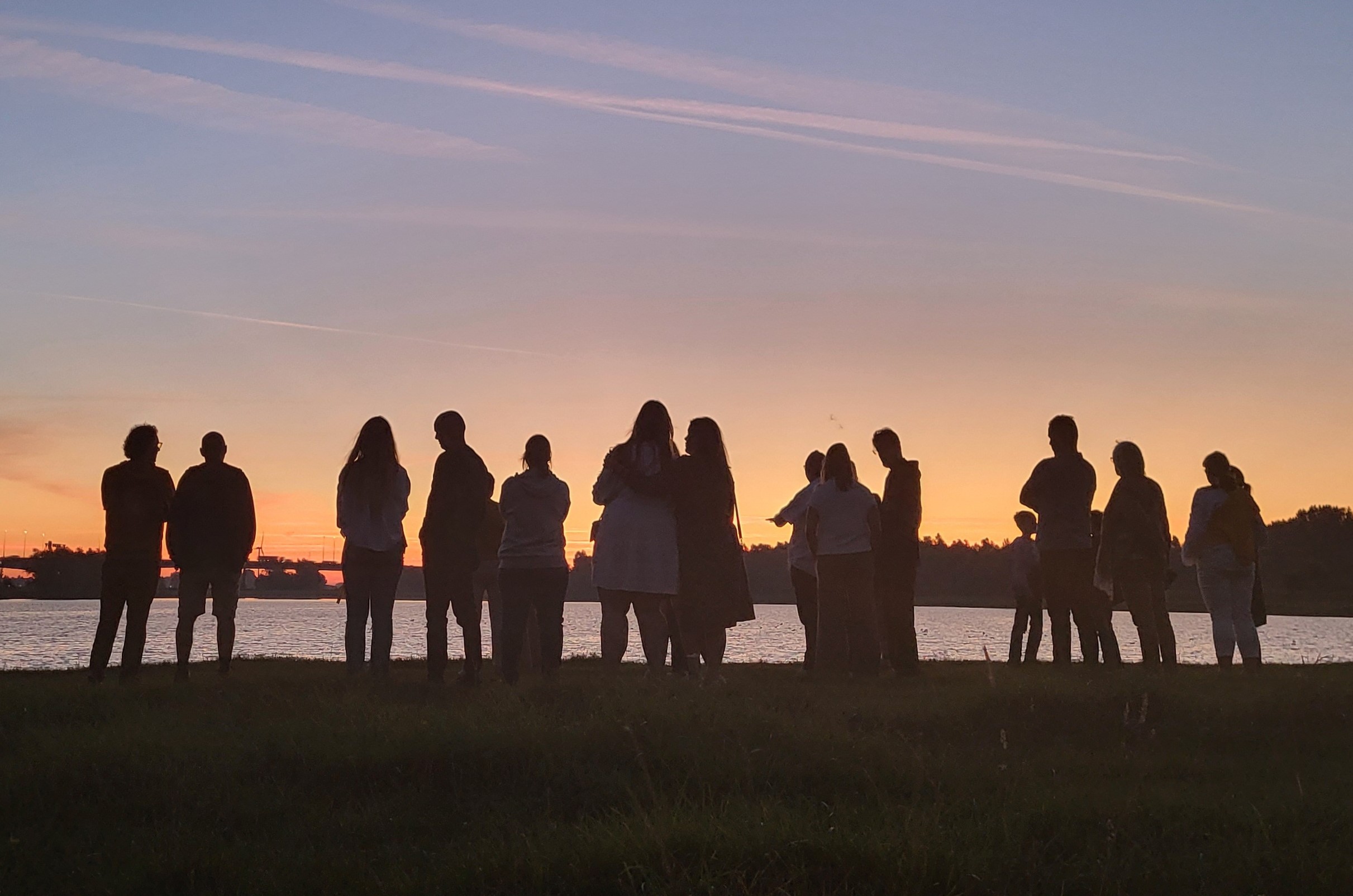 Groep mensen aan Kralingse plas bij zonsopgang